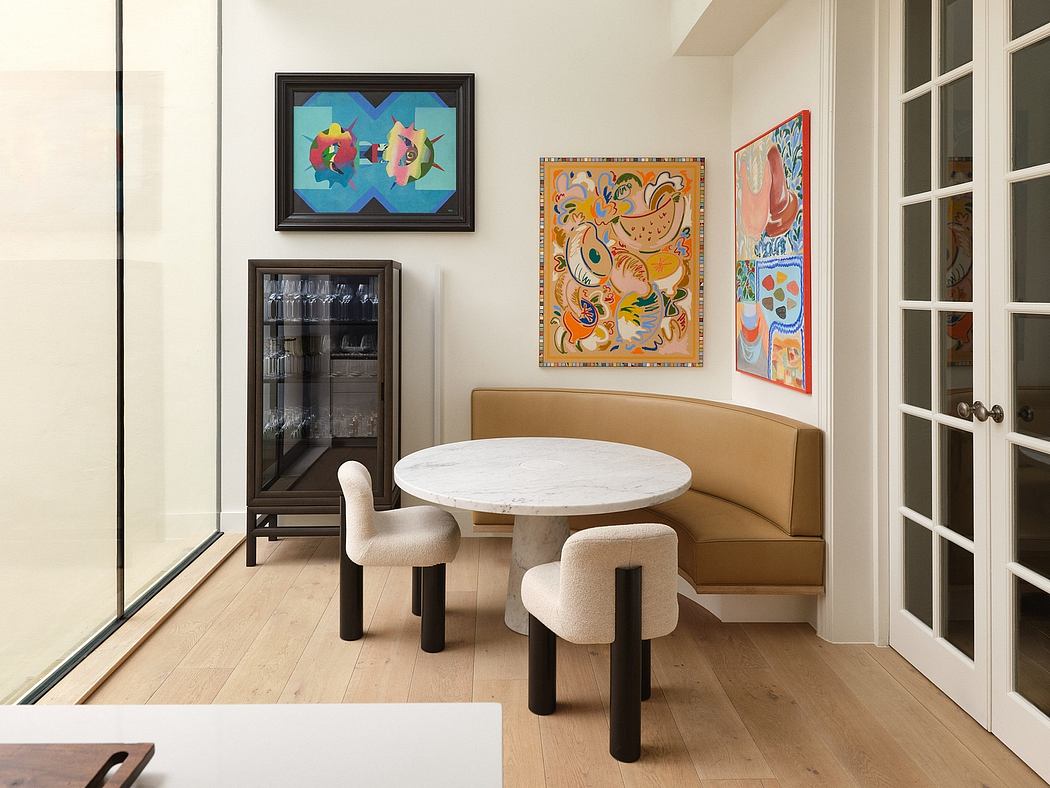 Modern and vibrant dining area with marble table, plush seating, and artful decor.