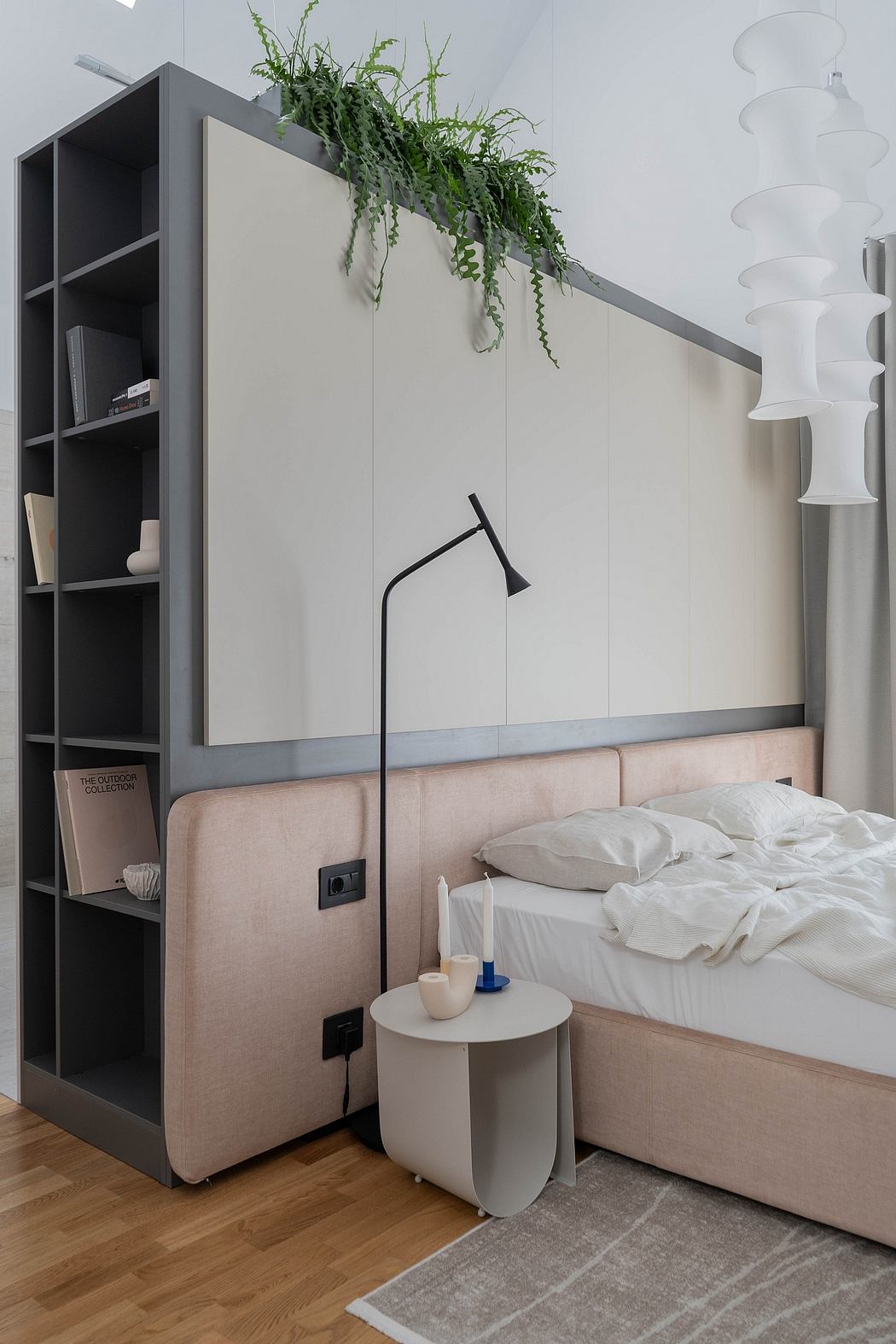 Modern bedroom with sleek gray shelving, hanging plants, and a cozy upholstered bed.