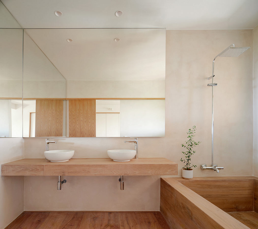 Spacious bathroom with a minimalist wooden vanity, dual sinks, and a modern shower.