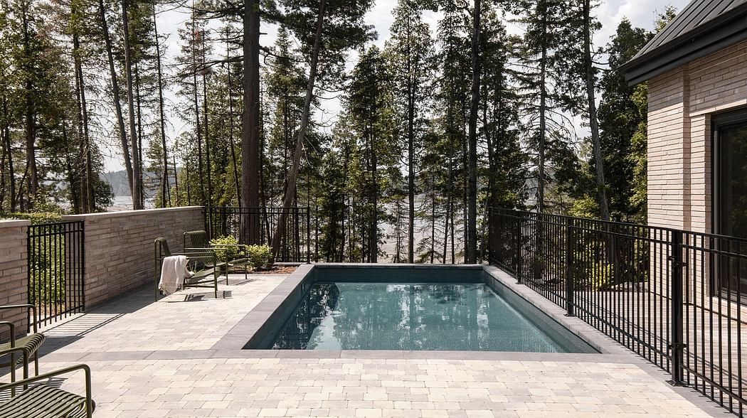 Tranquil lakefront setting with a modern, stone-clad home and an inviting pool.
