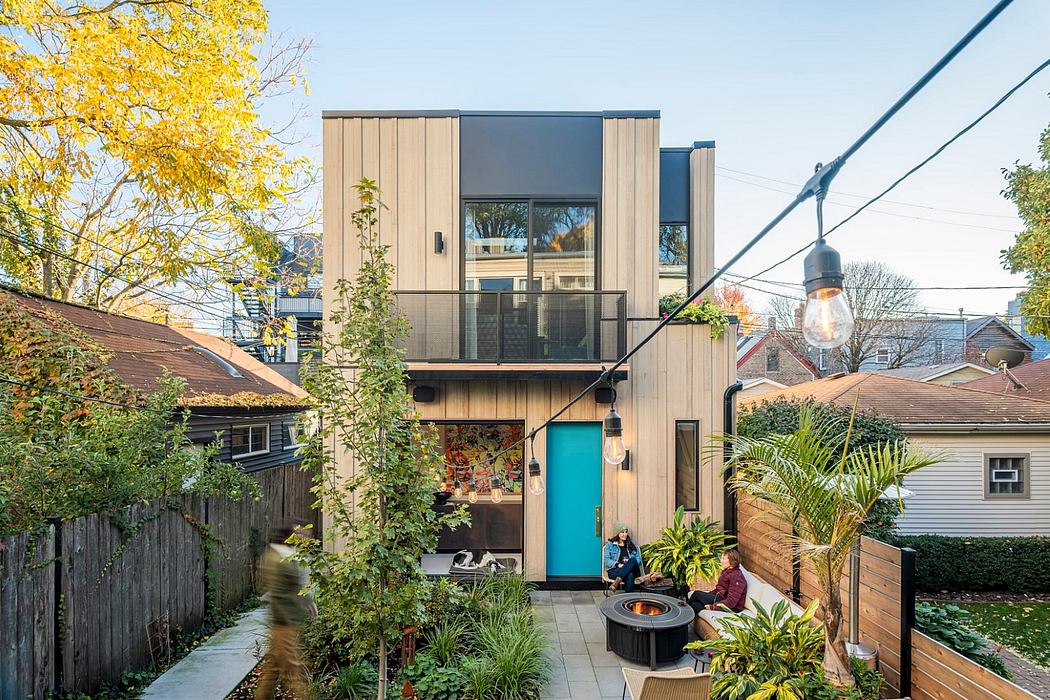 Modern, two-story timber-framed home with turquoise entryway, lush garden, and patio seating.