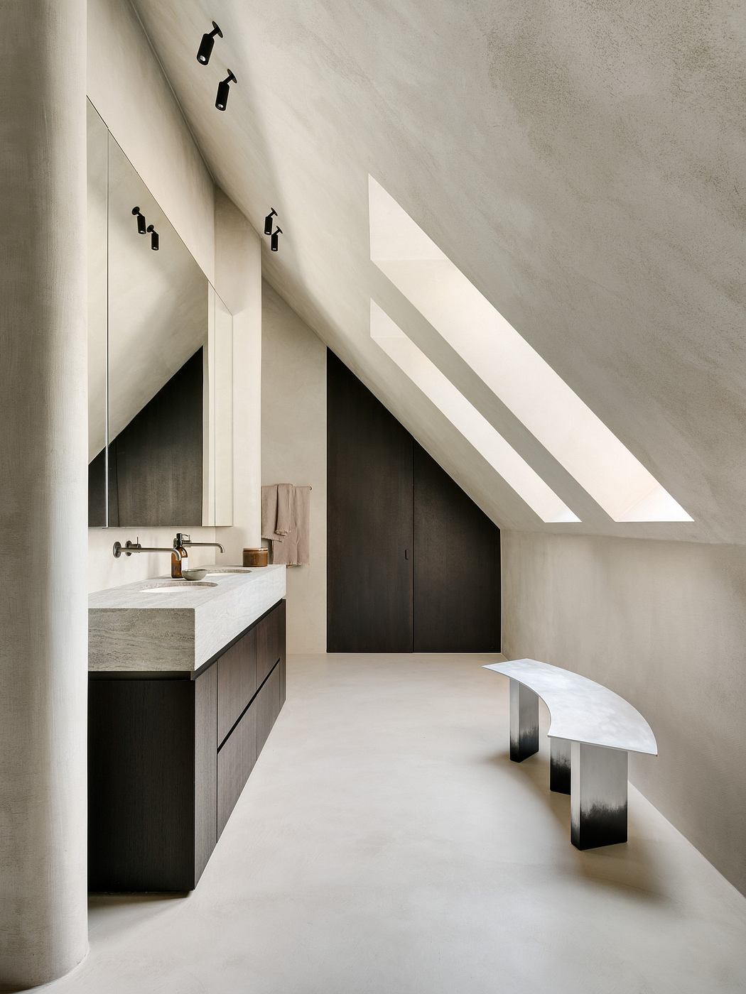 A minimalist bathroom with a sleek, angular design and recessed lighting.