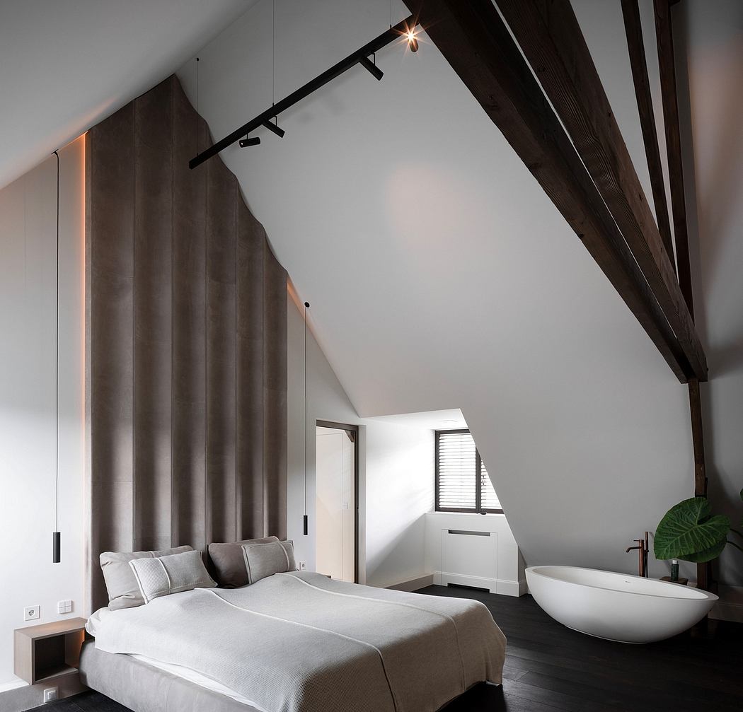 Minimalist bedroom with wooden beams, track lighting, and a freestanding bathtub.