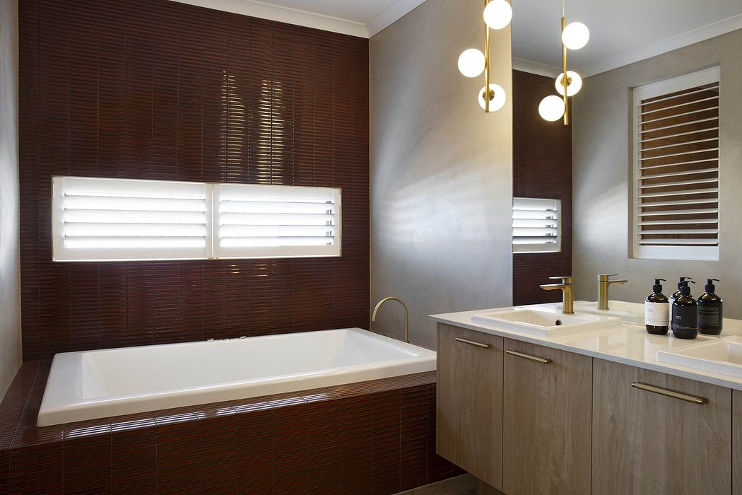 Sleek modern bathroom with wood-paneled walls, tub, vanity, and pendant lighting.