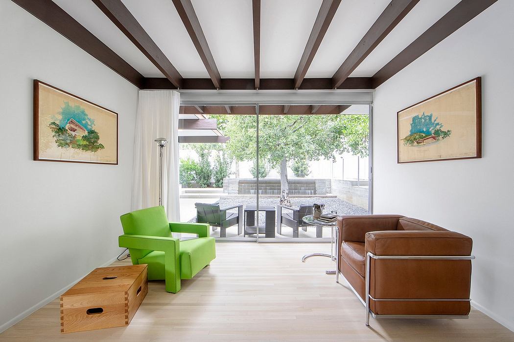 Bright, open living space with wooden beams, large windows, and mix of modern and rustic furniture.