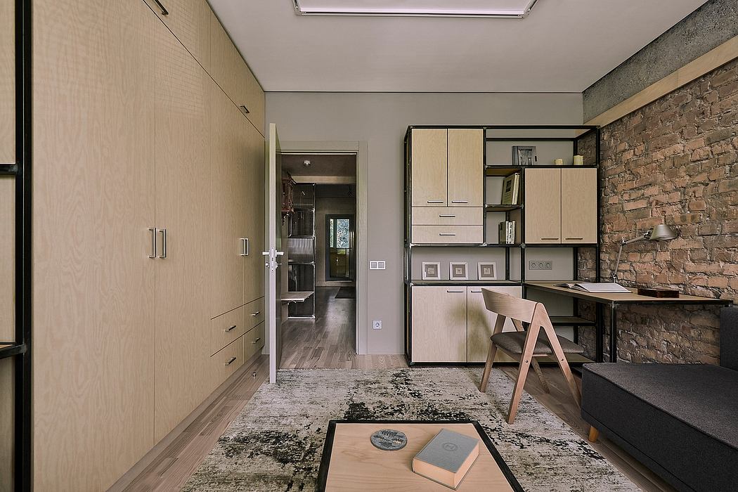 Modern apartment interior with minimalist furniture, exposed brick wall, and built-in storage.