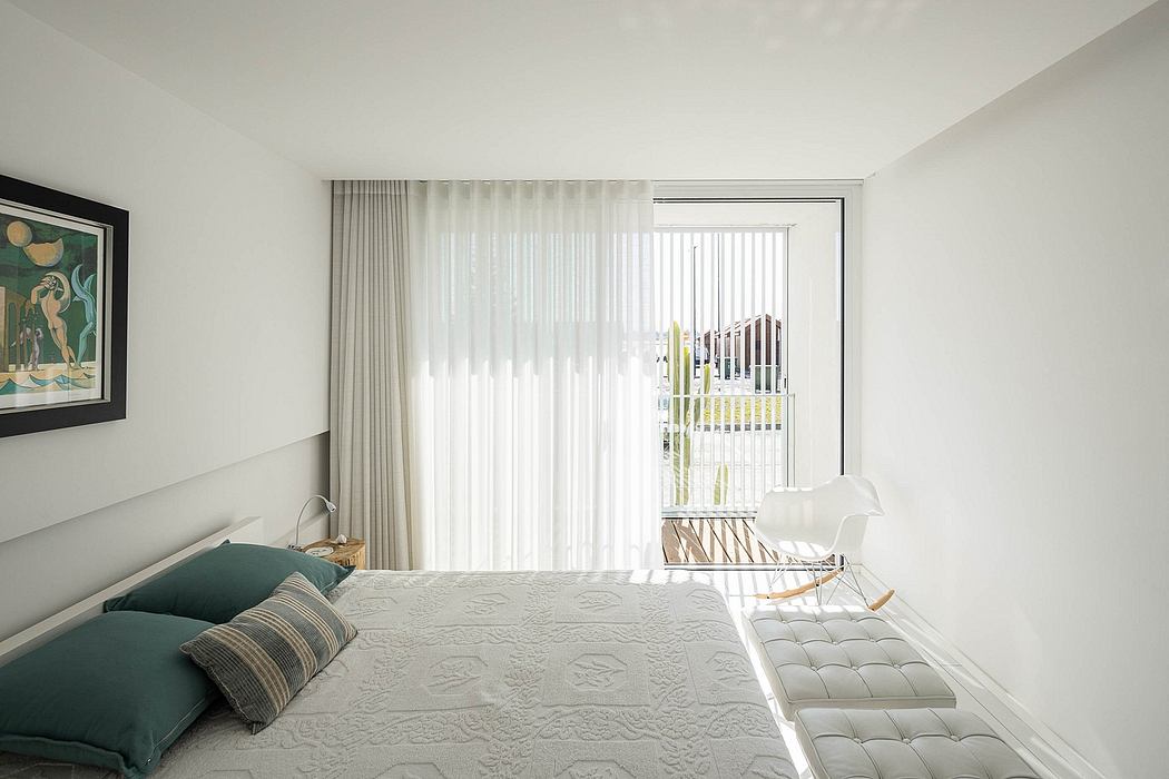 Bright, modern bedroom with minimalist furniture, neutral colors, and decorative artwork.