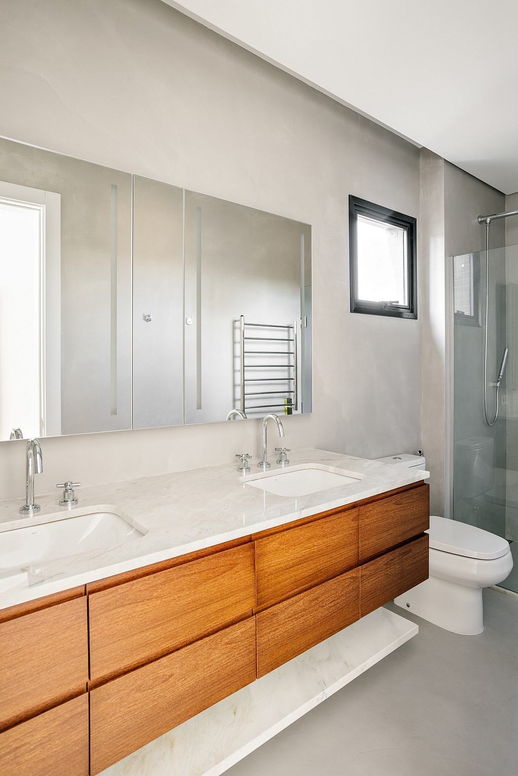 Modern bathroom with wooden vanity, white marble countertop, and recessed lighting.