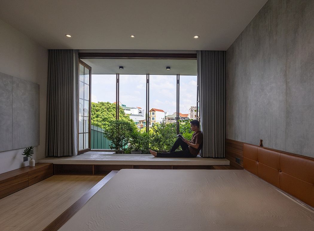 Large glass windows overlook lush greenery in this minimalist, modern bedroom.