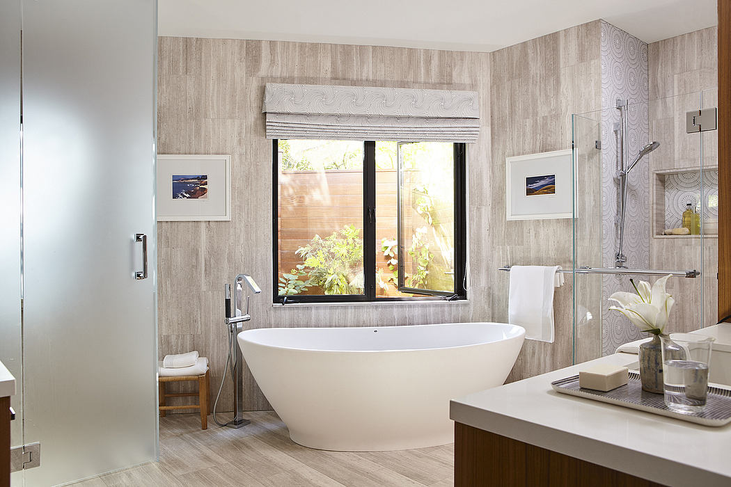 Elegant bathroom with freestanding tub, textured wall panels, and large window with garden view.