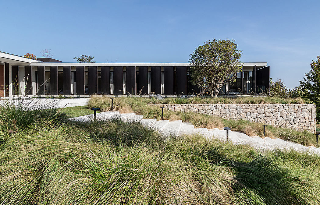 Modern architecture with lush landscaping and stone pathways leading to the building.