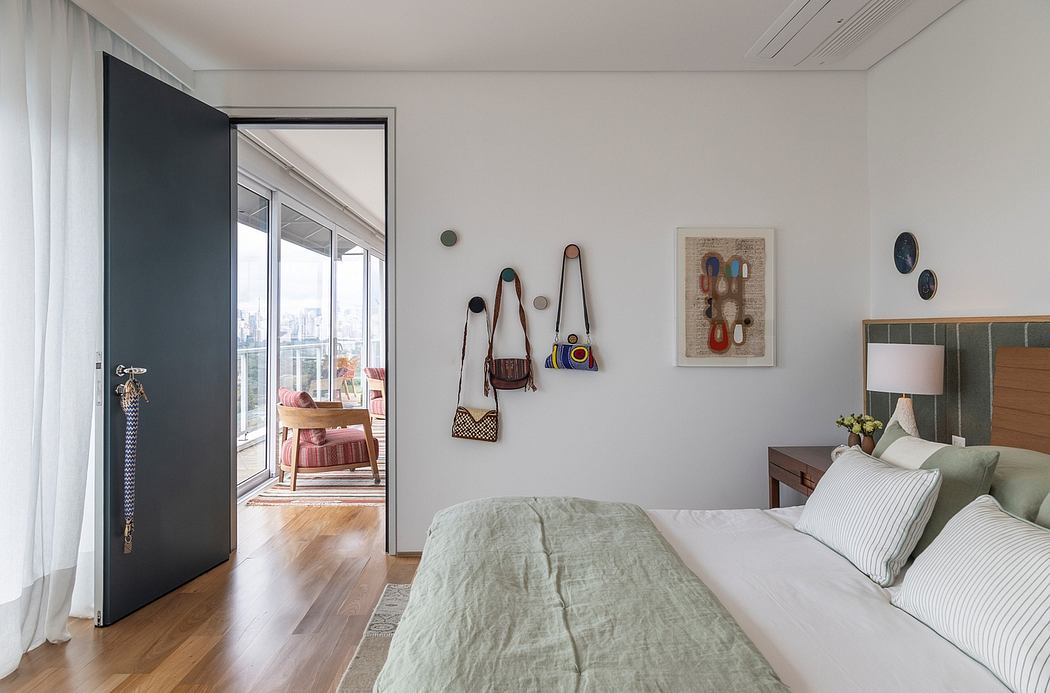 Spacious bedroom with wood flooring, neutral decor, and a balcony overlooking the city.