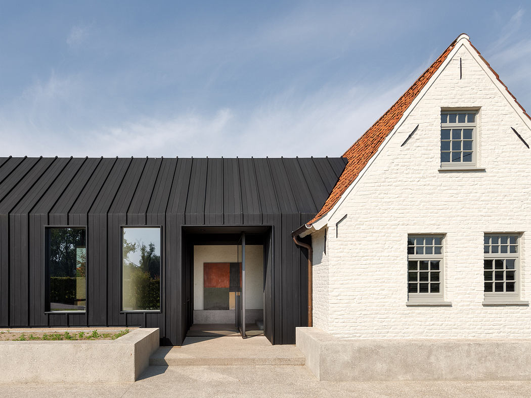 A modern architectural contrast of black metal siding and a historic white brick building.