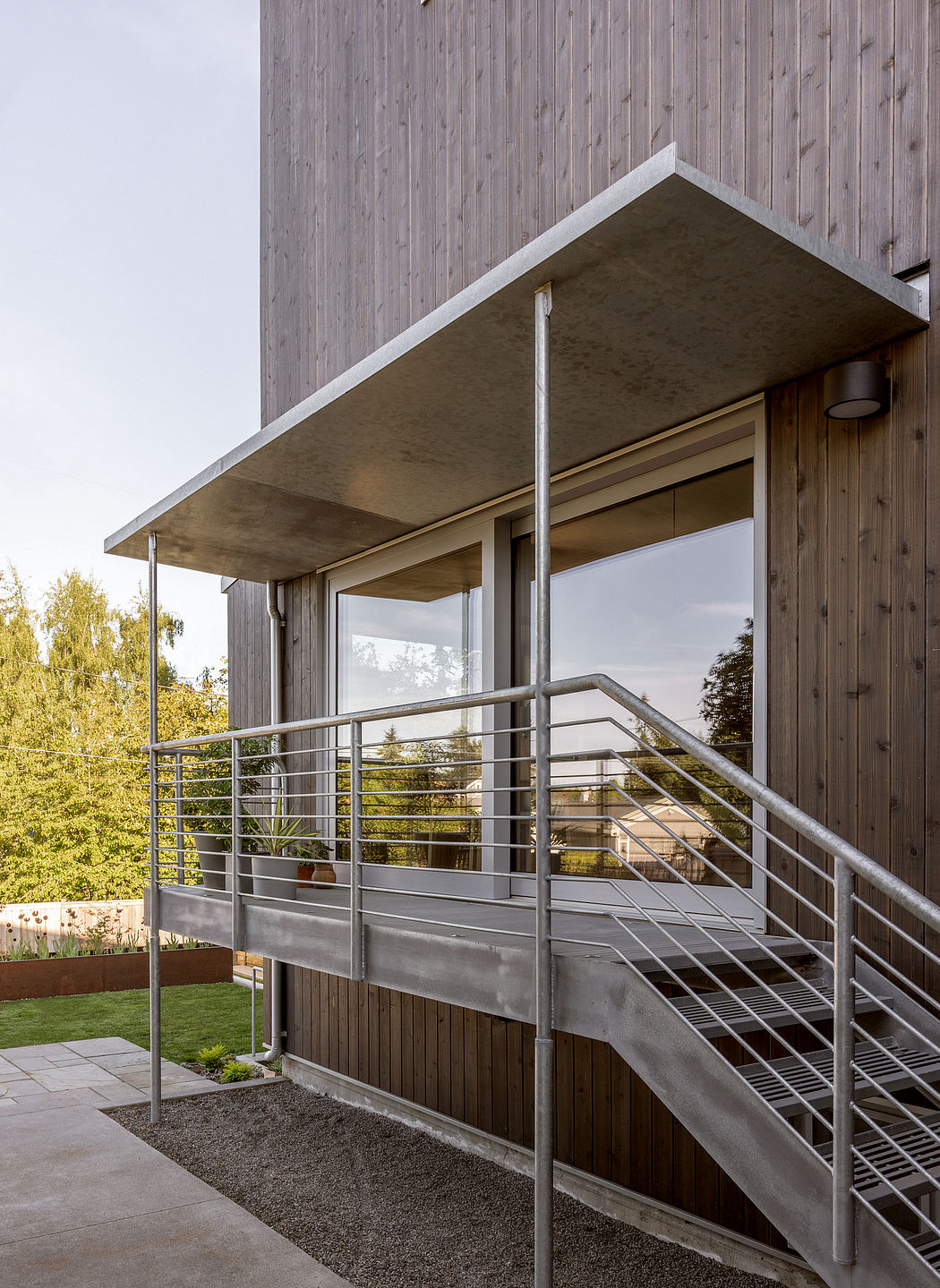 Sleek, modern architecture with clean lines, patio, and metal railing details.