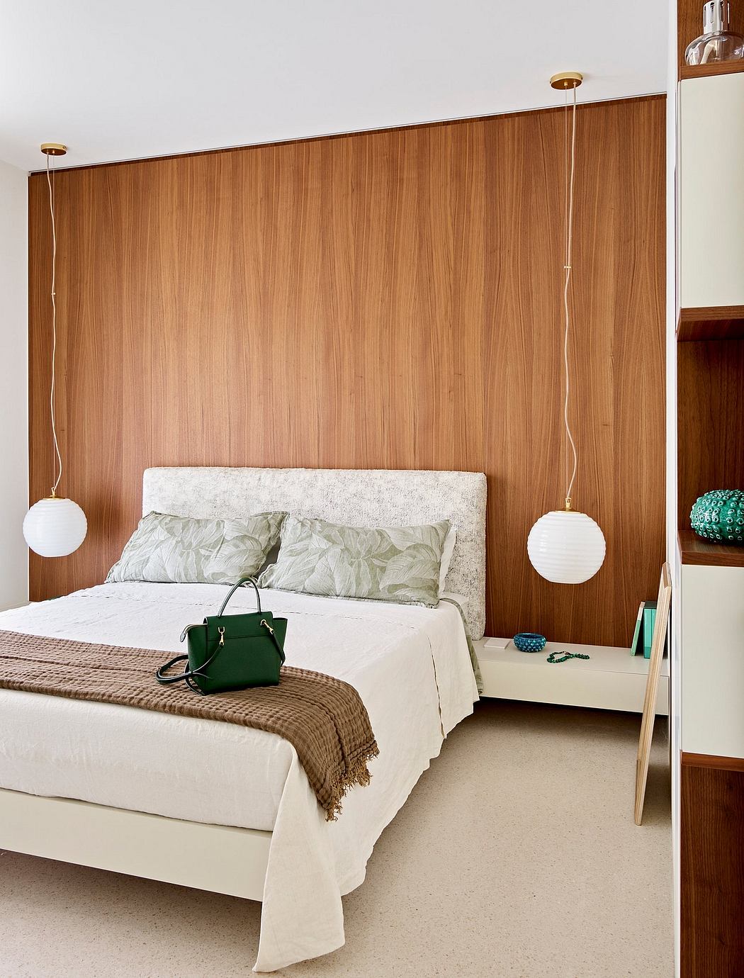 Warm-toned wood paneling, minimalist decor, and pendant lighting create a serene bedroom.