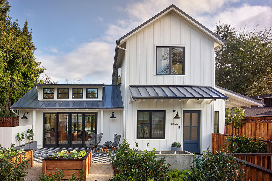 Charming modern farmhouse-style home with large windows, metal roof, and cozy porch.