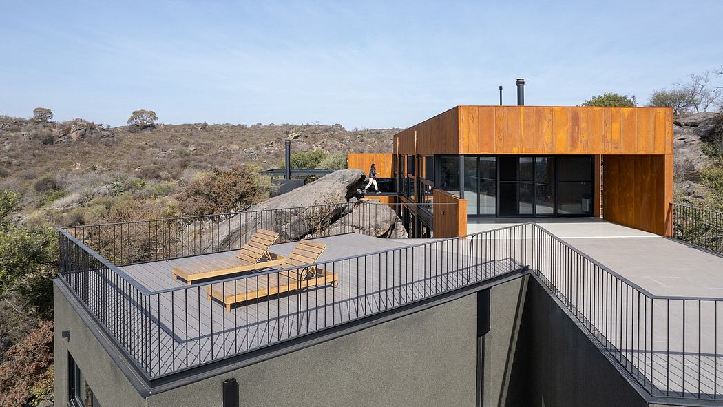 Modern wooden structure with balconies, stairs, and scenic landscape view.