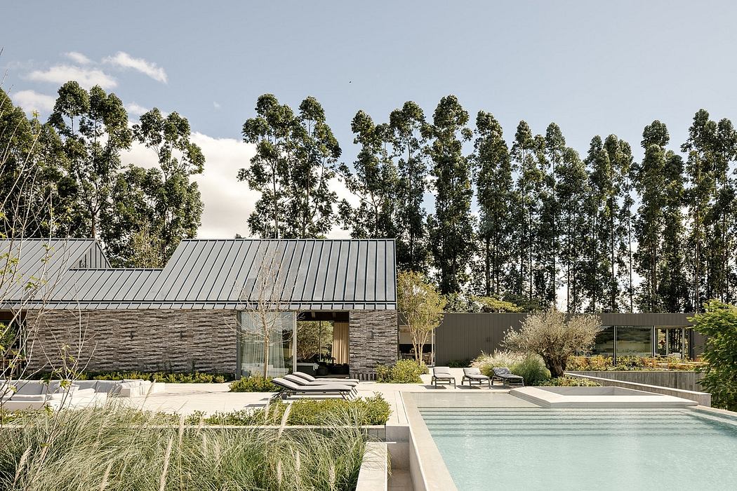 A modern, rustic house nestled among trees, with a sleek pool and minimalist landscaping.