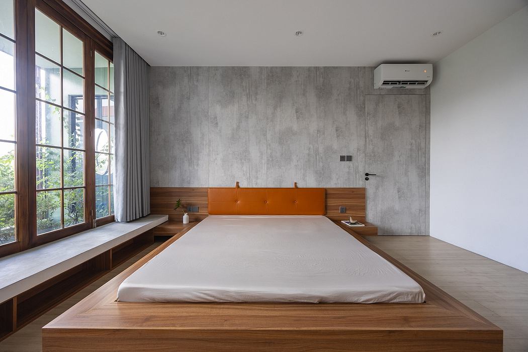 Sleek, modern bedroom with concrete walls, wooden platform bed, and expansive window.