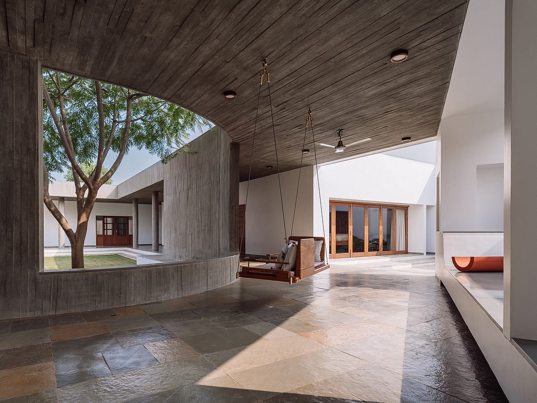 Expansive modern interior with textured wood ceiling, slate floors, and suspended swing.