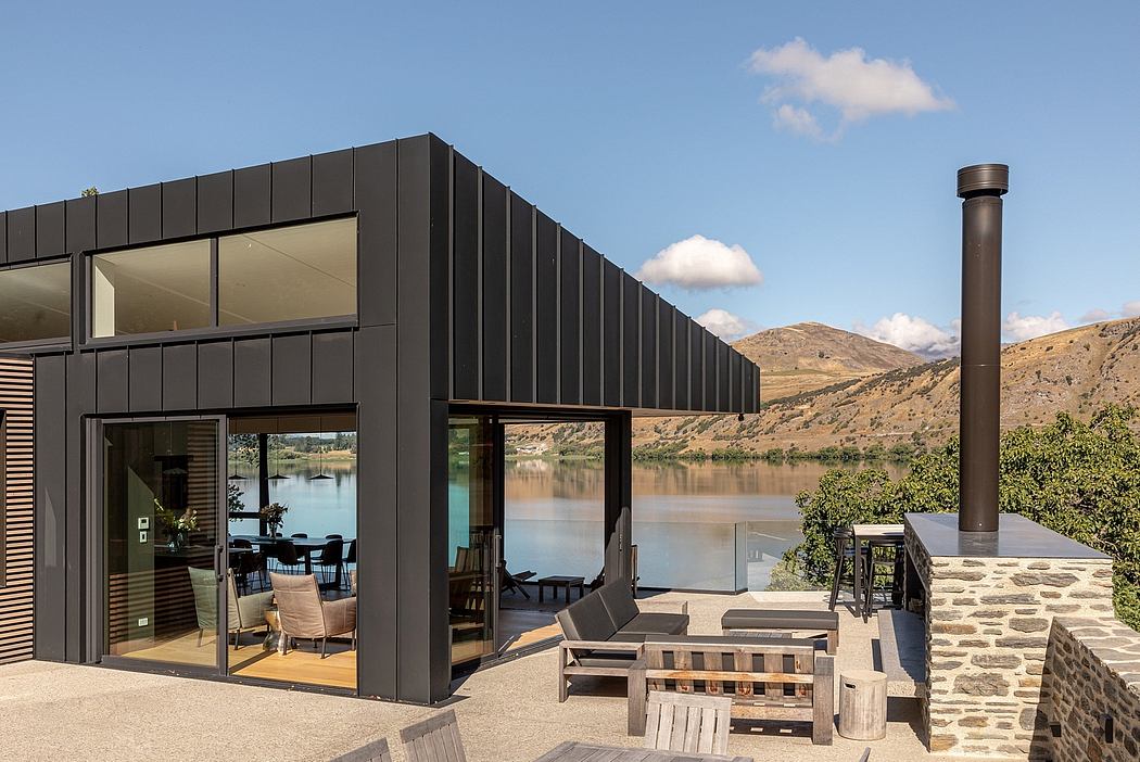 Contemporary lakeside retreat featuring sleek black facade, minimalist decor, and idyllic water views.