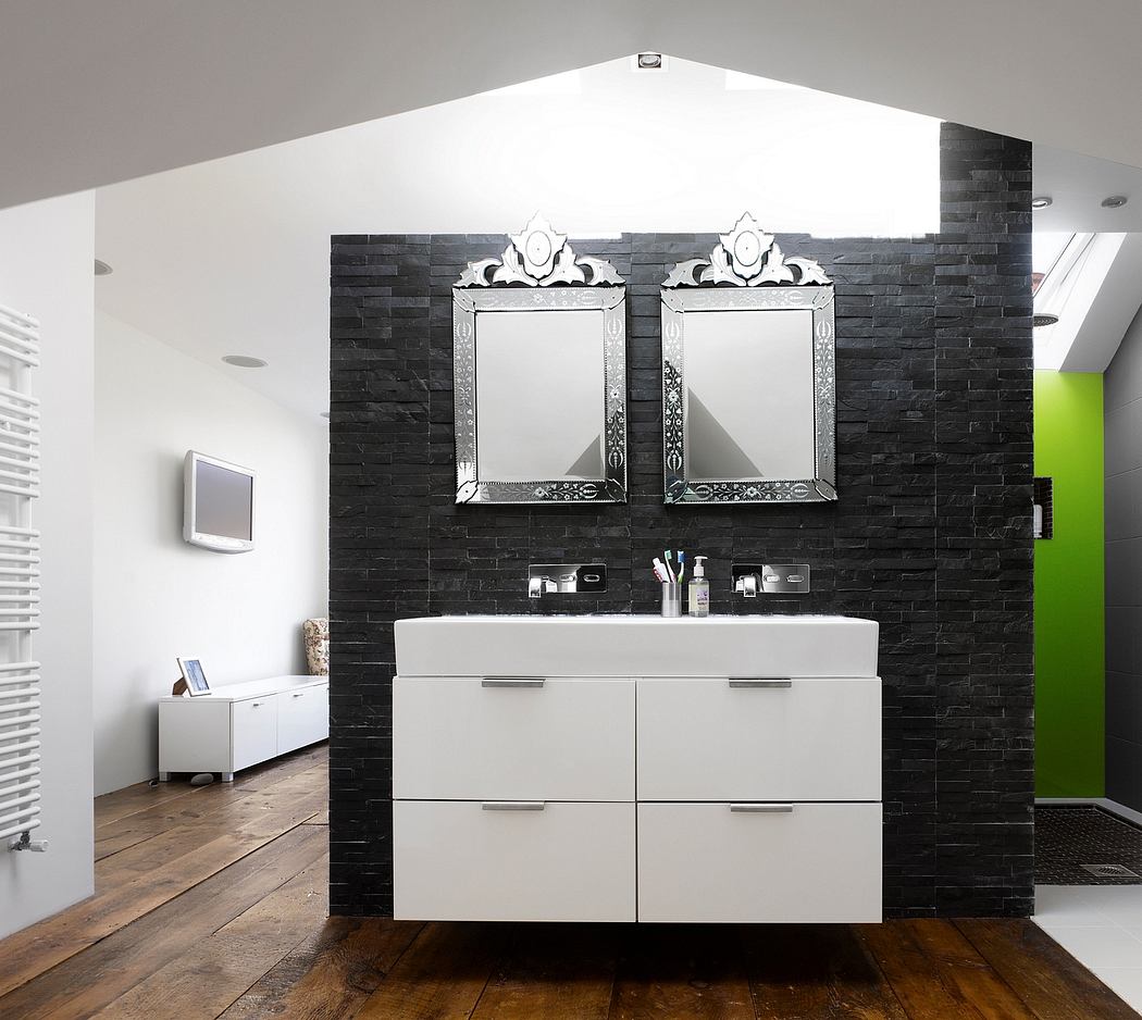 Modern bathroom with black brick wall, large white vanity, and ornate mirrored frames.