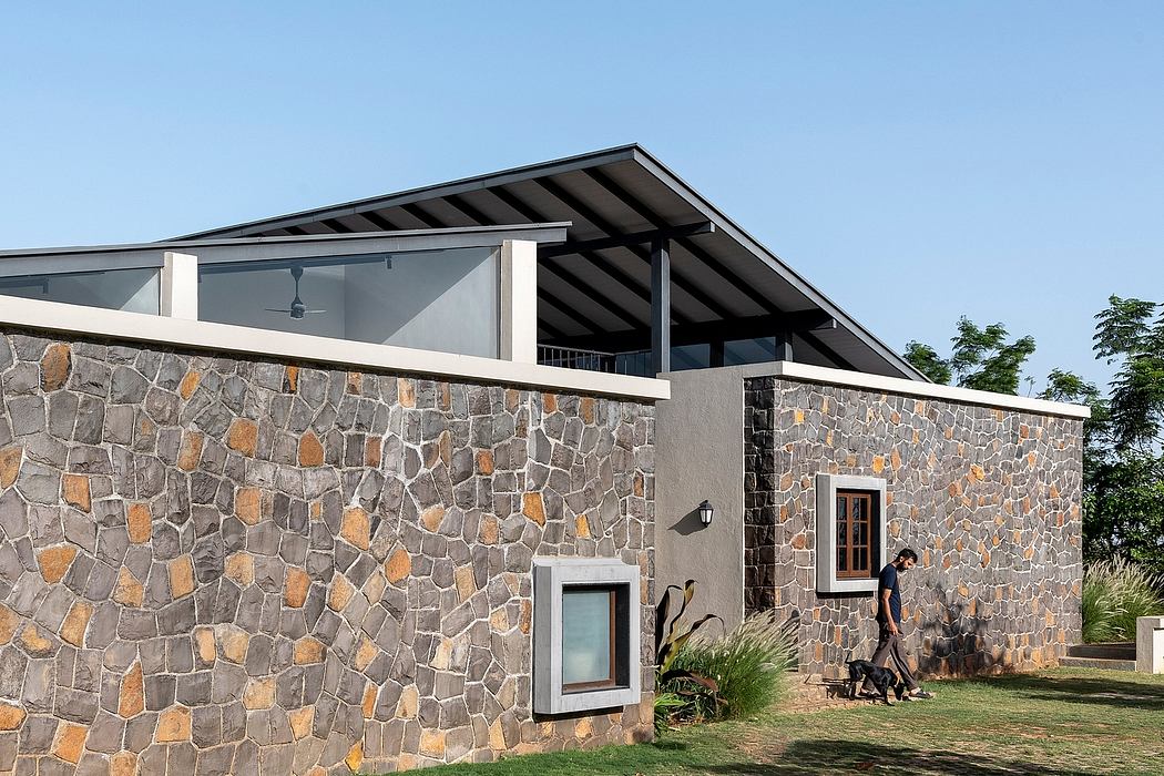 Striking stone exterior with sleek modern roof and large windows showcasing an architectural design.