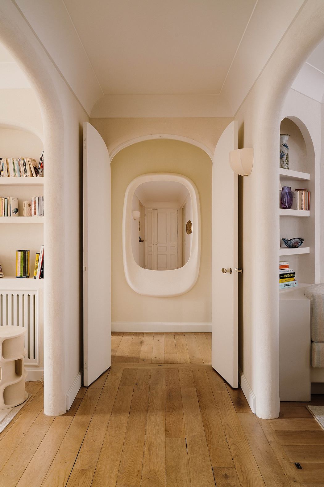 Warm, inviting entryway with arched doorway, built-in shelving, and hardwood floors.