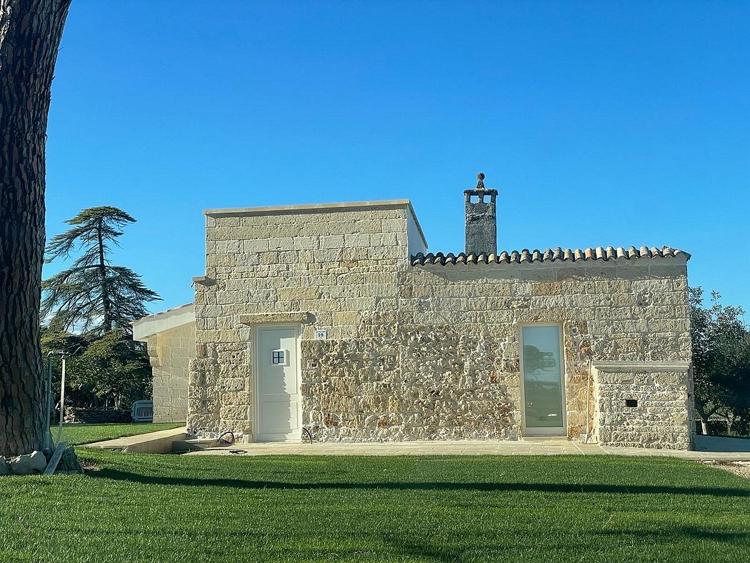 A stately stone structure with an ornate exterior and a prominent chimney, set against a clear blue sky.