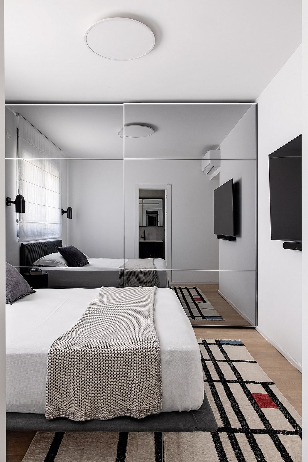 Minimalist bedroom design with clean lines, monochromatic palette, and strategic use of mirrors.