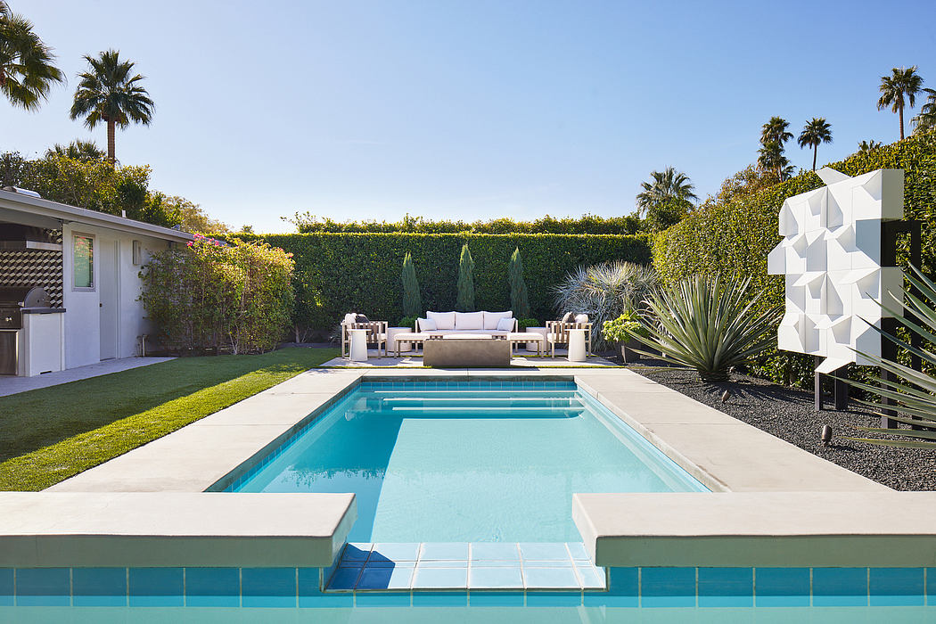 Spacious backyard with rectangular swimming pool, contemporary patio furniture, and lush landscaping.