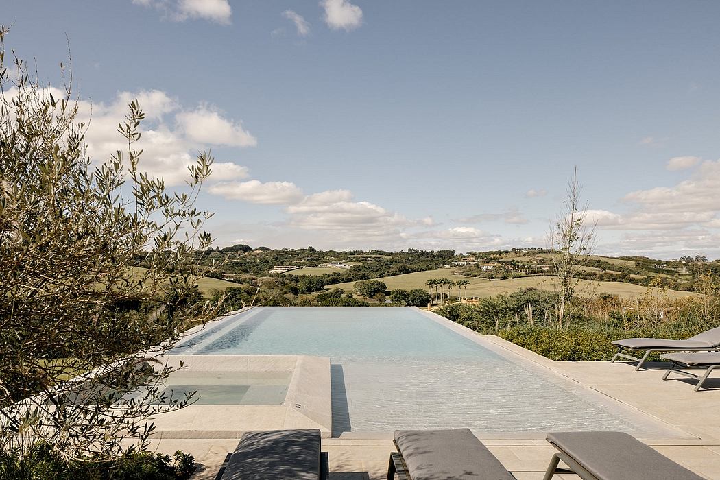 Tranquil infinity pool overlooking a lush, rolling countryside landscape.