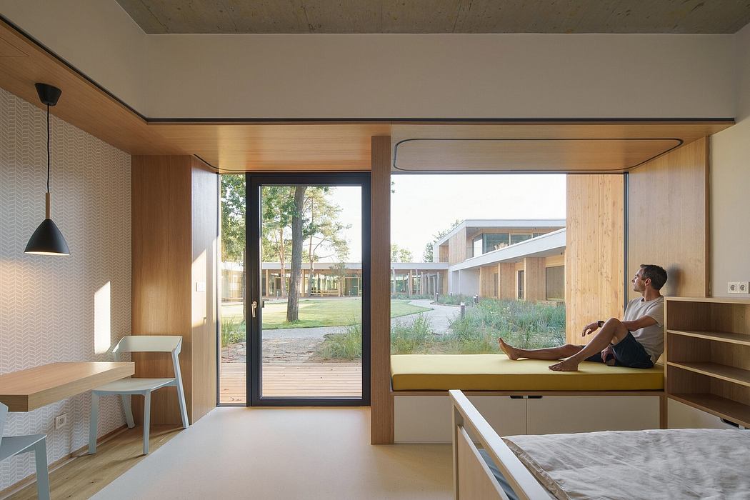 Modern, wood-paneled interior with large windows overlooking a landscaped courtyard. Minimalist furnishings and sleek design.