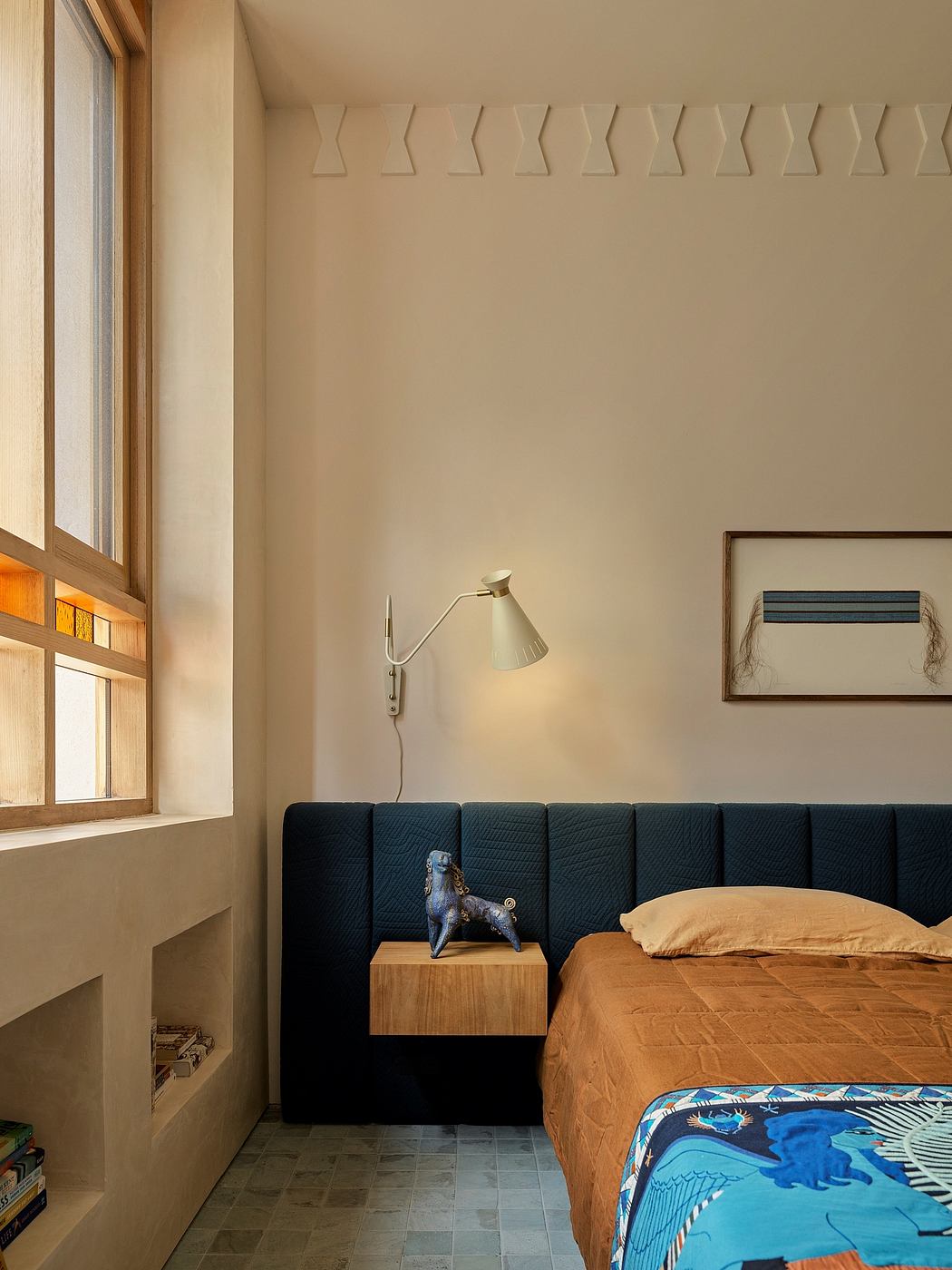 Cozy bedroom with minimalist decor, wooden accents, and a modern, textured headboard.