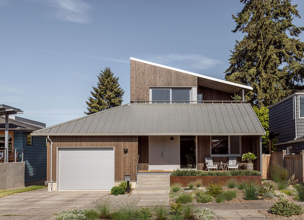 Modern two-story home with wood and metal exterior, large windows, and landscaped yard.