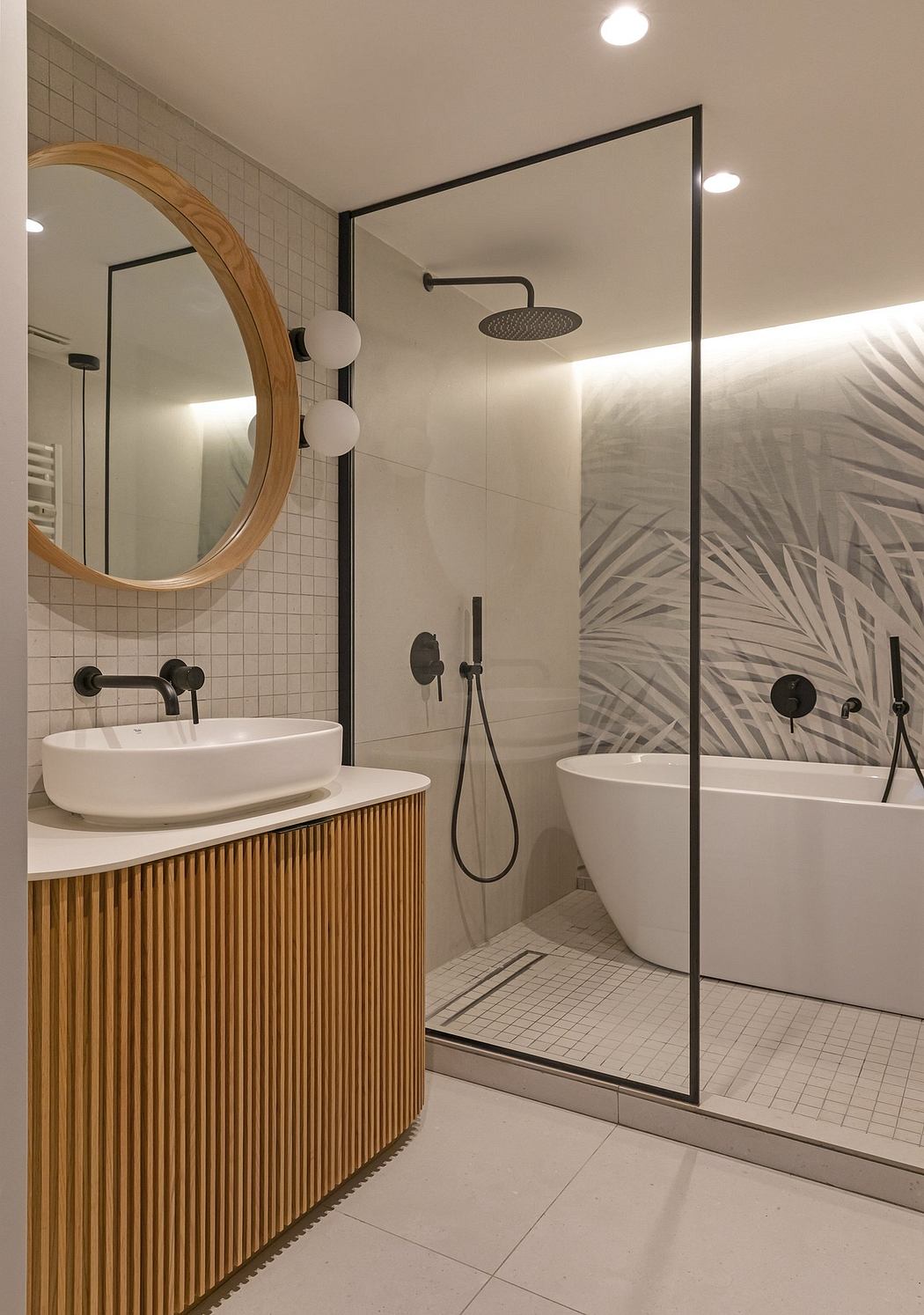 Minimalist bathroom with wooden vanity, round mirror, and tropical foliage wallpaper.
