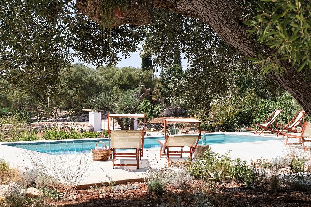 An idyllic outdoor pool area surrounded by lush vegetation and rustic furniture.