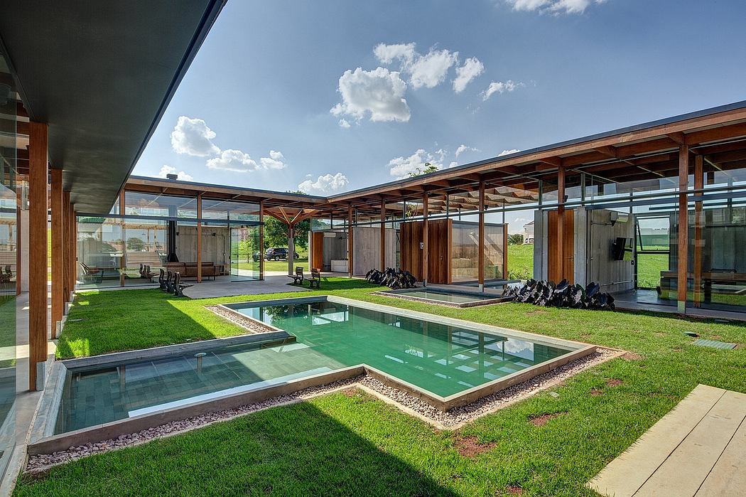 Spacious, glass-enclosed patio with a rectangular pool, surrounded by a lush, green lawn.
