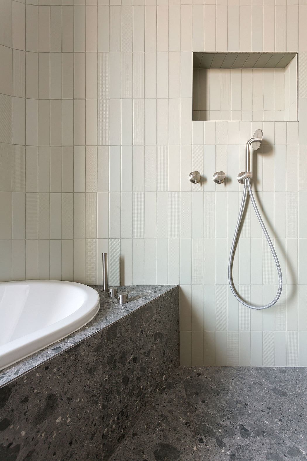 Minimalist bathroom with rectangular tile pattern, granite countertop, and modern shower fixture.