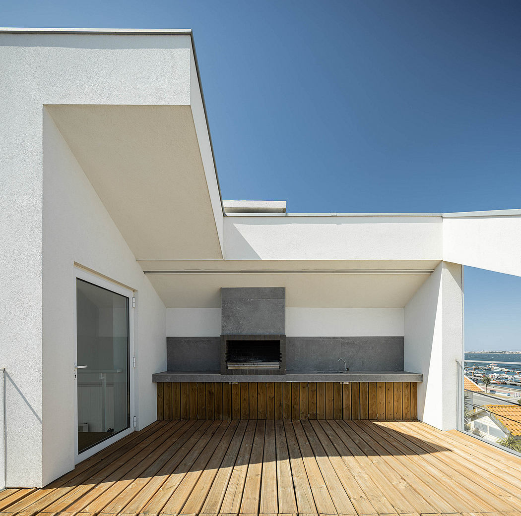 A modern outdoor kitchen and seating area with a sleek concrete countertop and wooden deck.