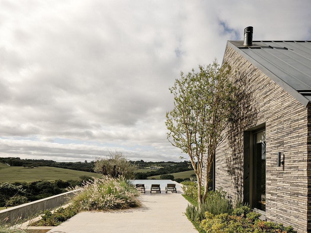 Contemporary brick structure with lush landscaping and scenic rural views.