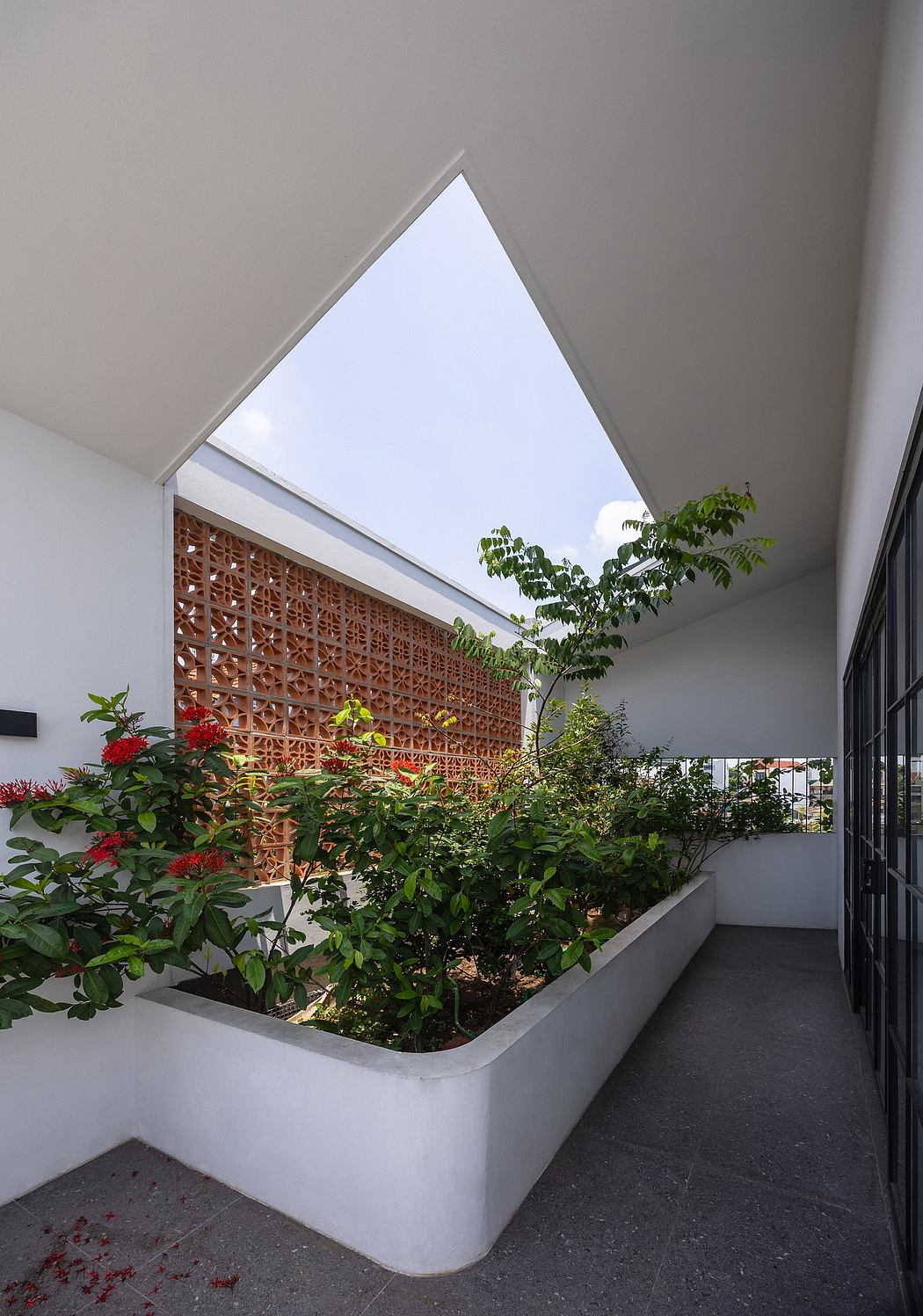 Airy indoor garden with geometric lattice screen and skylights.
