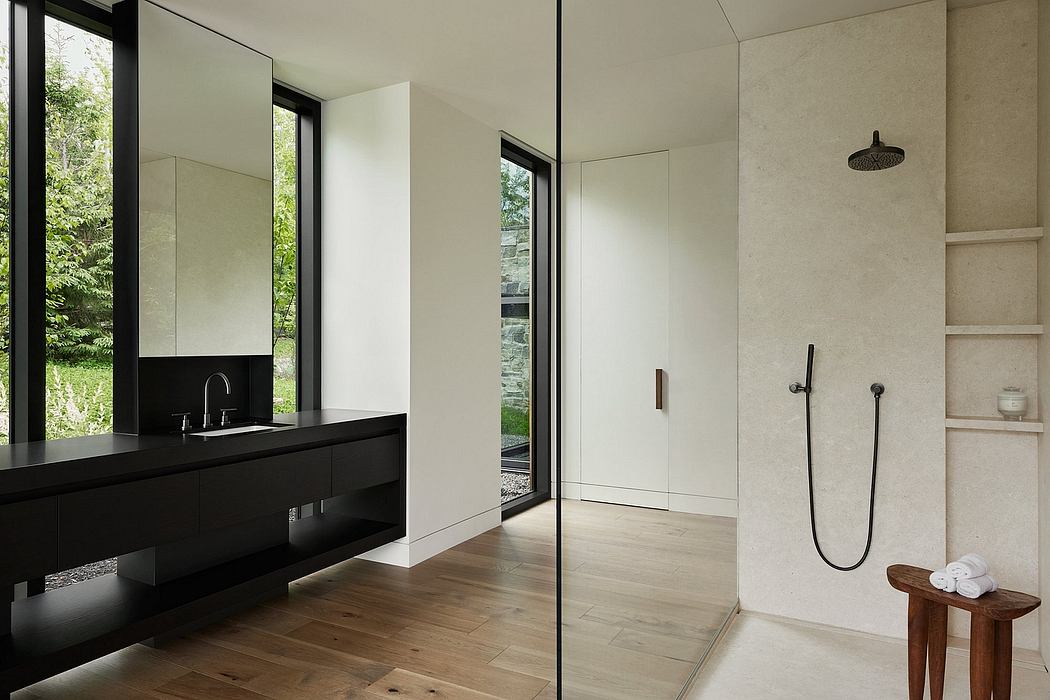 Sleek modern bathroom with black vanity, large mirrors, and a glass-enclosed shower.
