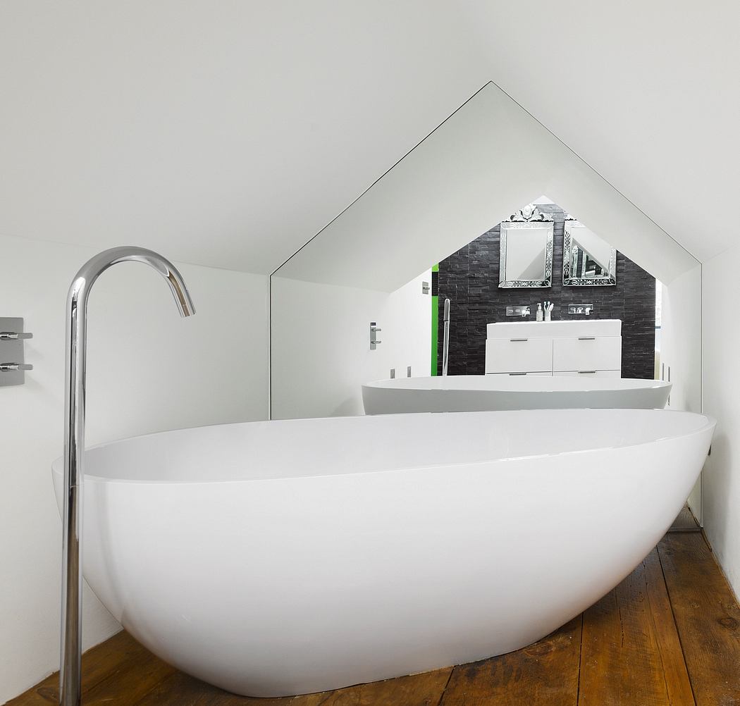 A modern bathroom with a freestanding white bathtub, vanity unit, and textured wall.