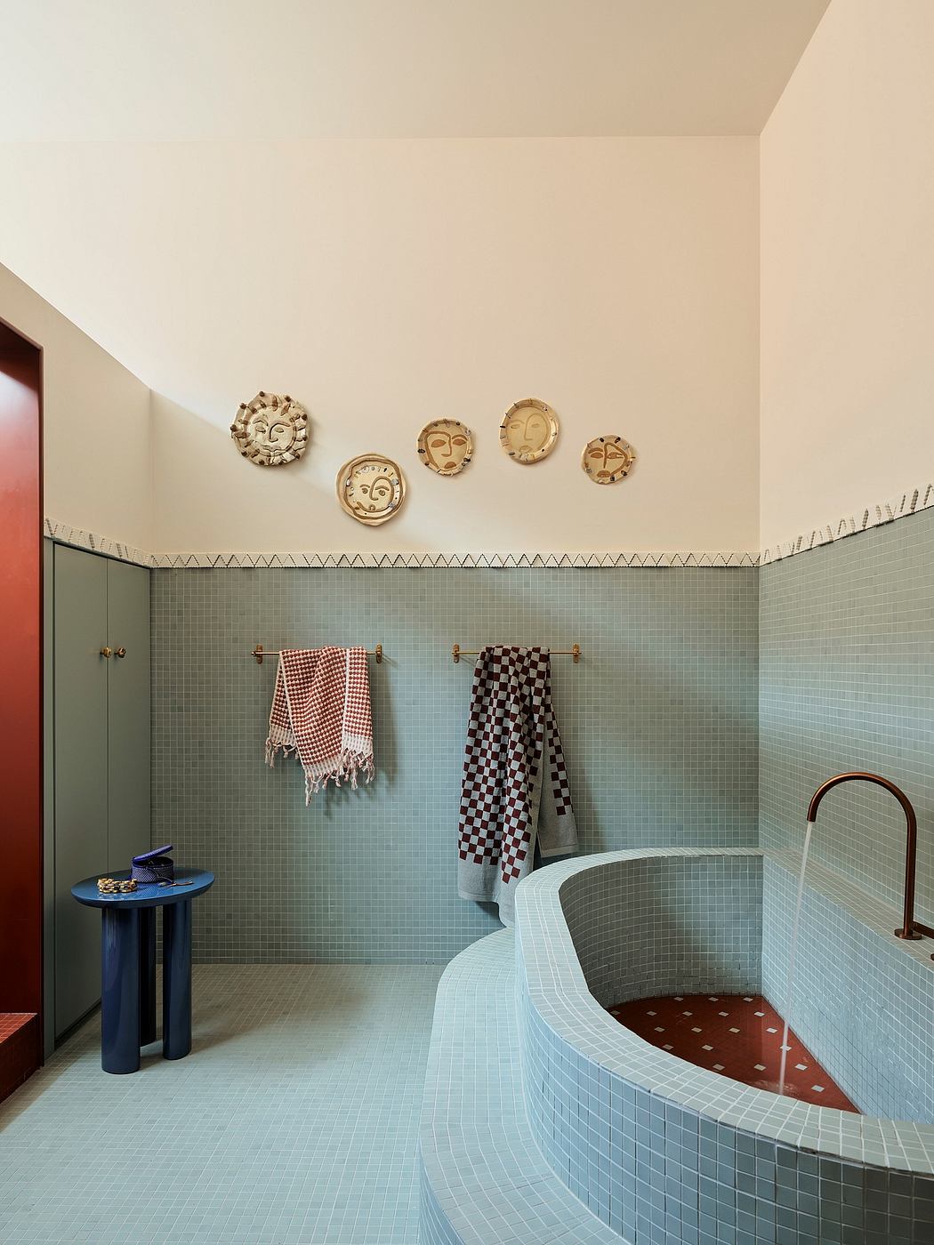 Vibrant bathroom design with unique tiled walls, circular tub, and decorative wall art.