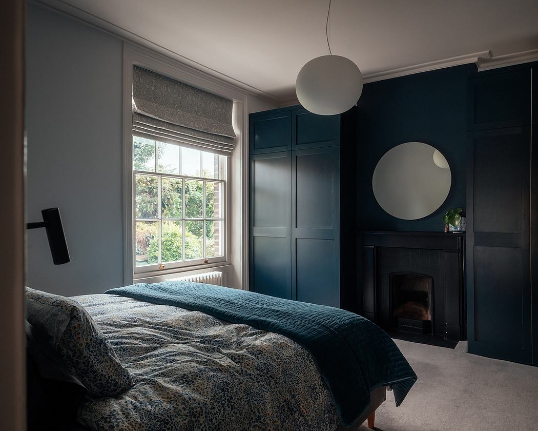 Cozy bedroom with dark blue wardrobe, circular mirrors, and a fireplace in the corner.