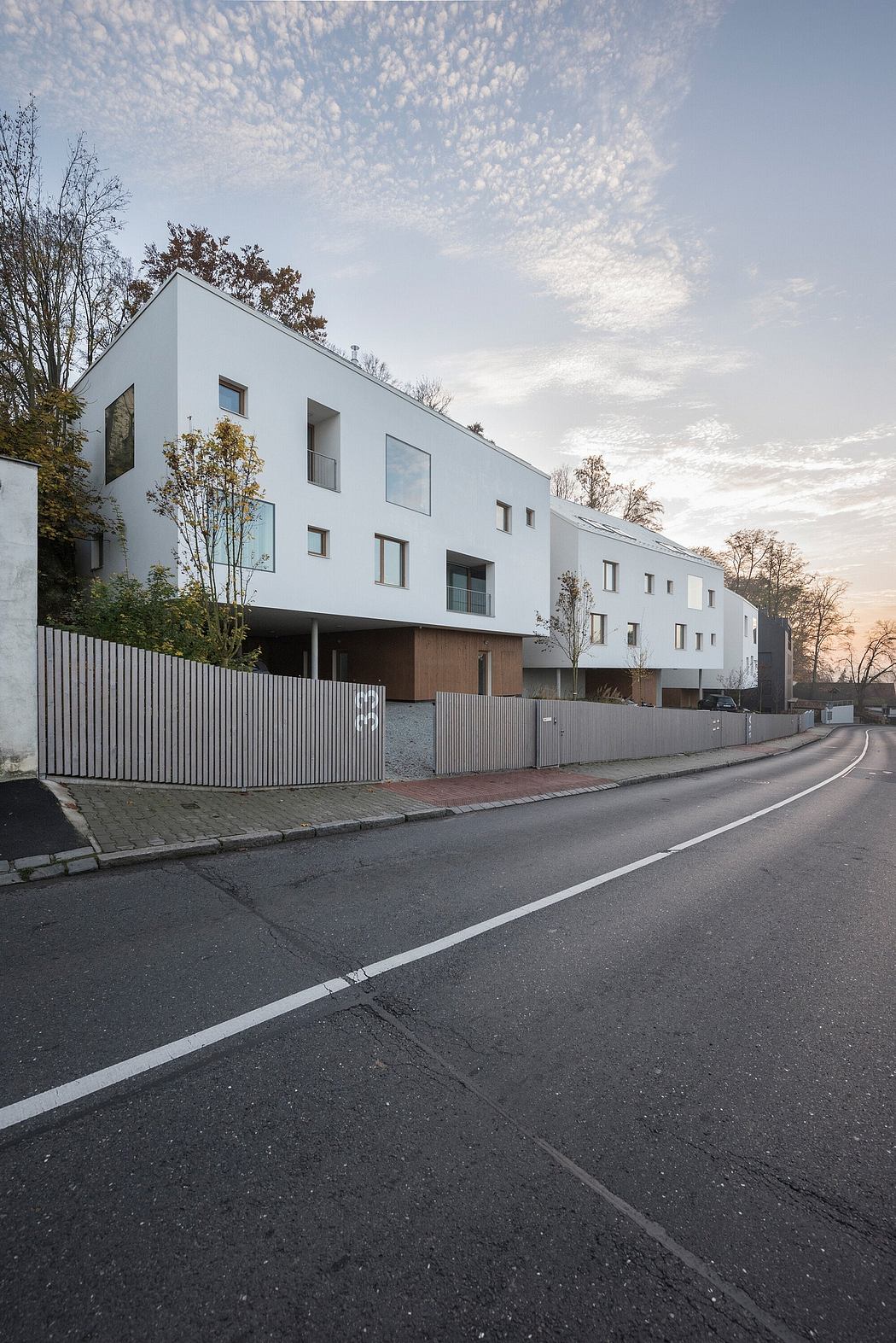 A modern, multi-story residential building with minimalist design and architectural details.