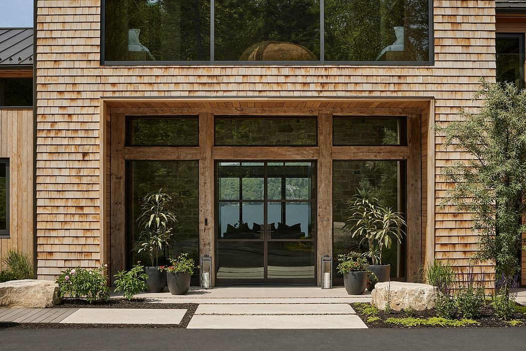 Rustic wooden exterior, large glass windows, and planters framing the entrance.