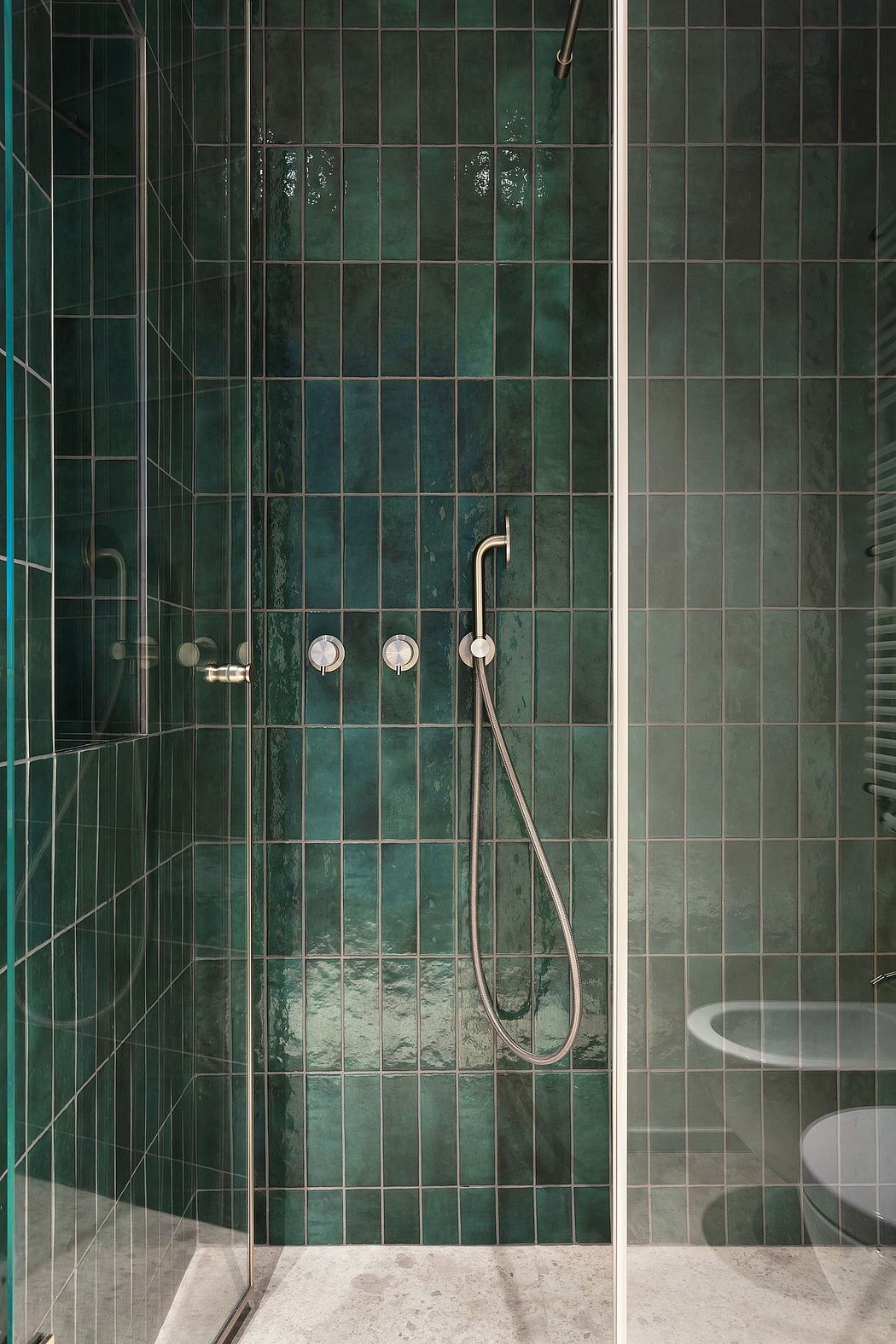 Minimalist bathroom with tiled walls, modern shower fixtures, and white floor tiles.