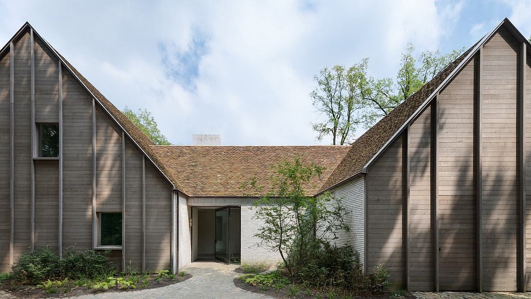 Asymmetrical exterior with varied roof angles, wood siding, and a central entrance.